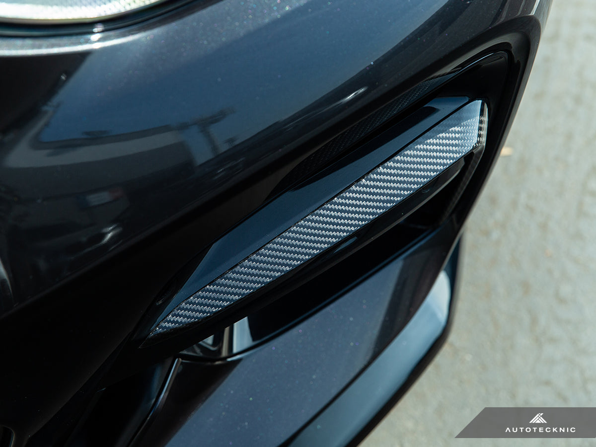 AutoTecknic Carbon Fiber Front Bumper Trim Set in silver-gray twill weave, fitted within a black bumper vent.