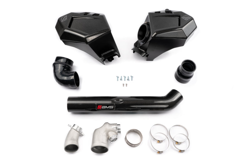 AMS Performance BMW G8X S58 air intake kit with black carbon fiber housings and tube, metal elbows and clamps.