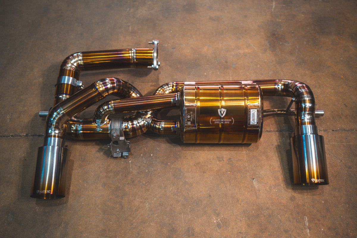 Lotus Emira Valved Sport Exhaust System in polished titanium, with curved pipes, central muffler and twin tips.