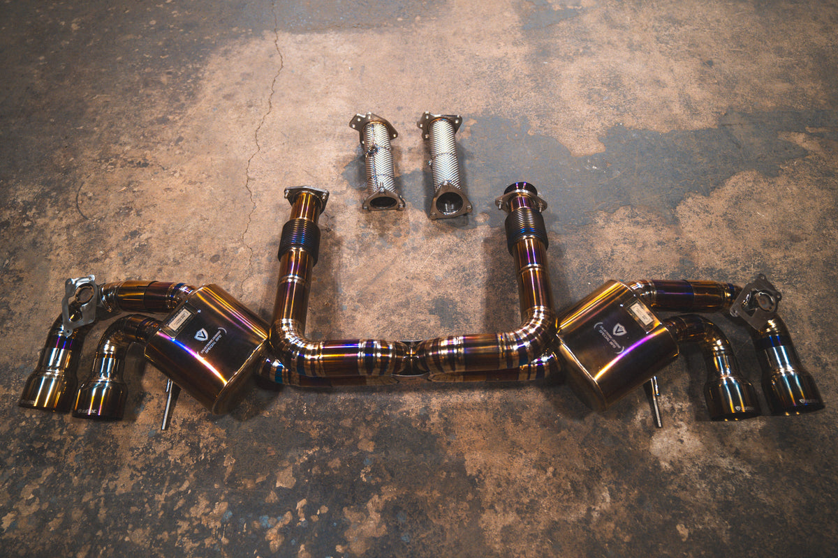 Chevrolet Corvette C8 valved sport exhaust system with dark metallic tubing, polished welds, twin mufflers and braided flex pipes.