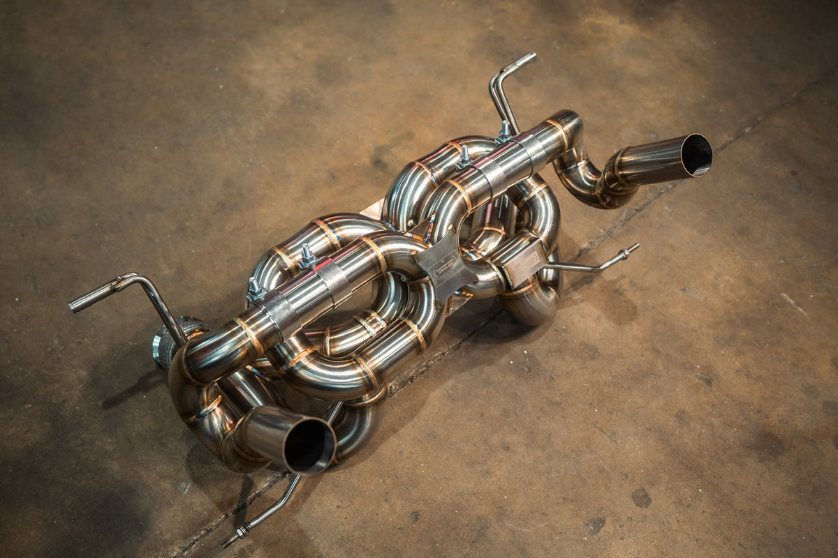 Exhaust system for Lamborghini Huracan Performante, polished stainless steel with intricate curved pipes and dual tips.