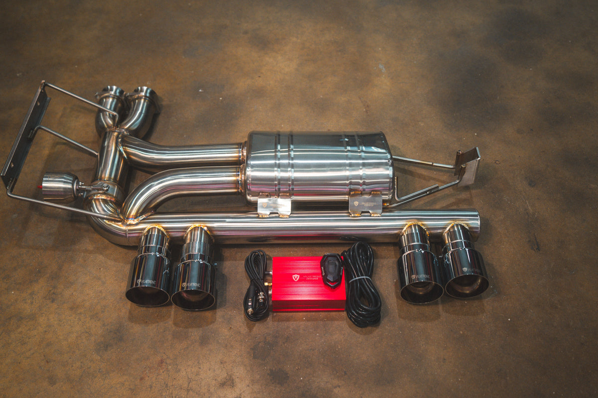BMW E46 M3 Valved Sport Exhaust with polished stainless steel tubing, central muffler, four black tips, and red controller.