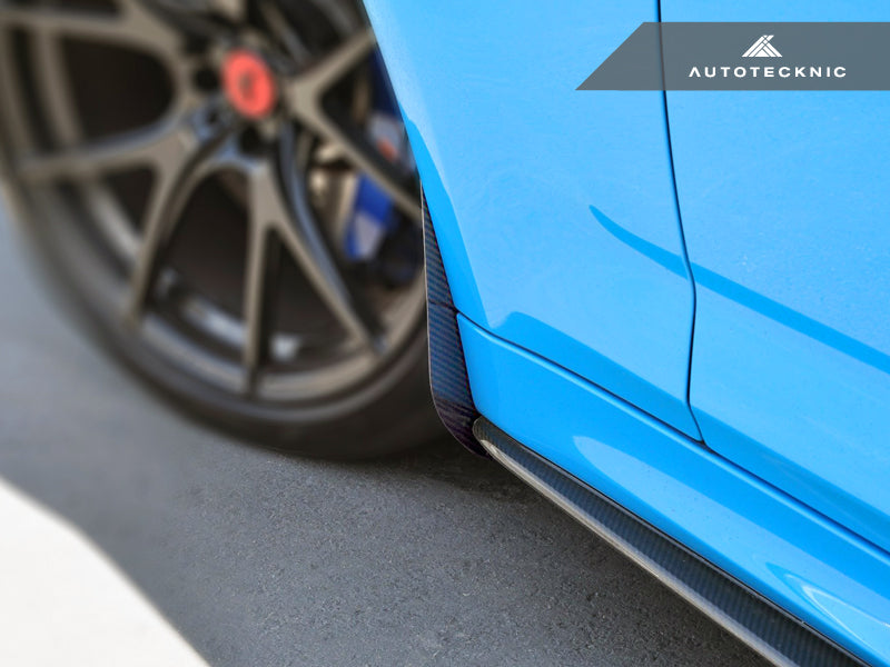 AutoTecknic Carbon Fiber Front Splash Guards, black twill-weave panels fitted along the blue car’s lower side edge.