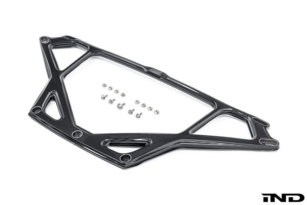 Eventuri BMW G8X M2 carbon strut brace with glossy black carbon-fiber weave, sculpted openings and metal mounting inserts.
