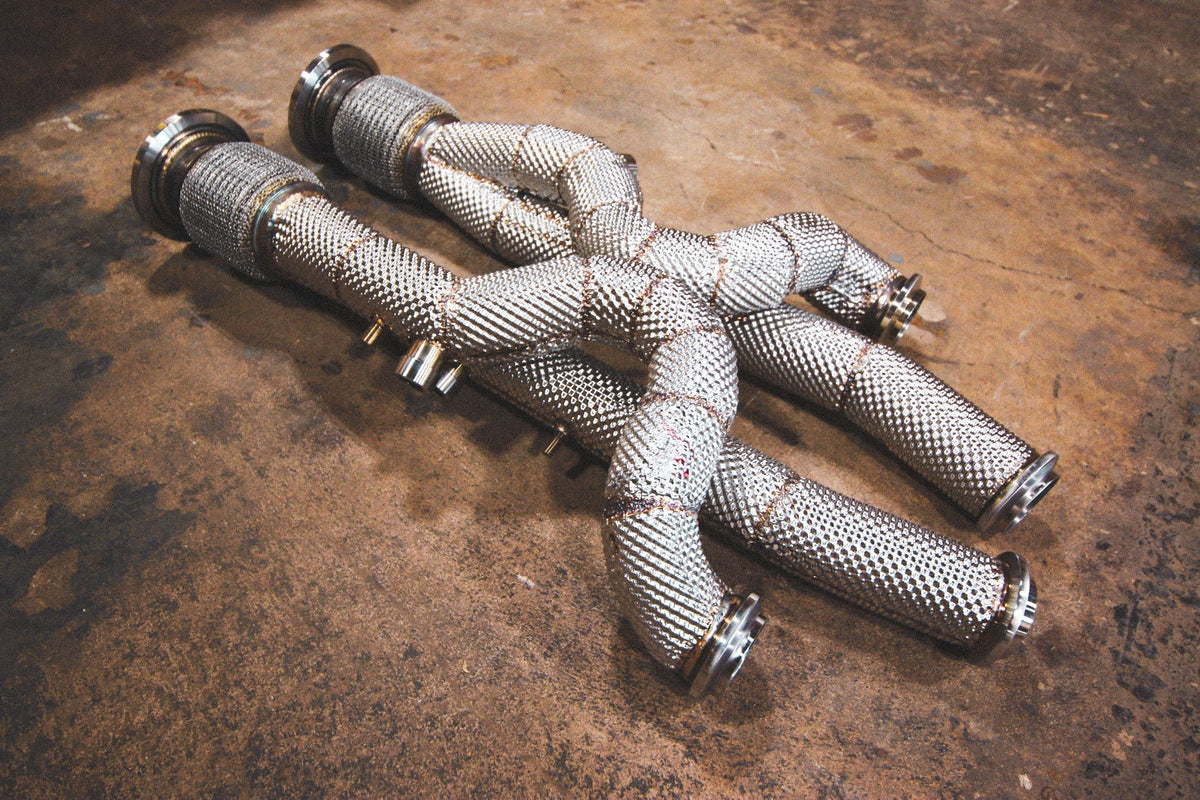 Front exhaust pipes for Lamborghini Aventador / S / SV / SVJ, silver metal with woven heat shielding and curved equal-length tubes.