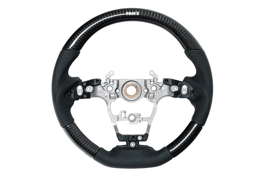 TOM'S Steering Wheel (Carbon)OEM factory replacement for Toyota GR Yaris &amp; GR Corolla- OEM switches and airbag can be used- High-quality perforated black leatherSteering WheelTOM's Racing