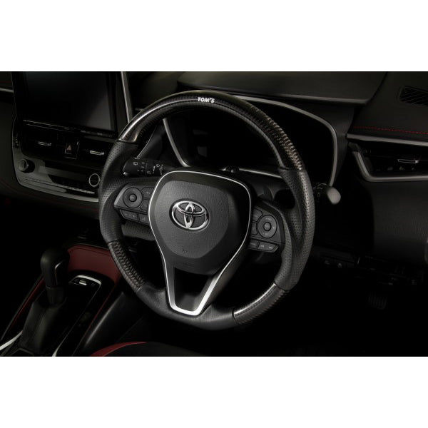 TOM'S Steering Wheel (Carbon)OEM factory replacement for 2019+ Toyota Corolla Hatchback Models- OEM switches and airbag can be used- High-quality perforated black leSteering WheelTOM's Racing